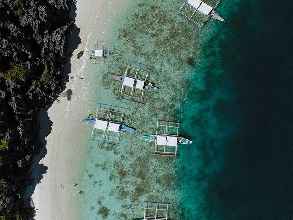 outriggers mooring on a tropical beach
