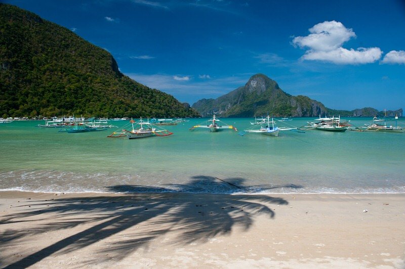 tranquil anchoring outrigger boats in el nido